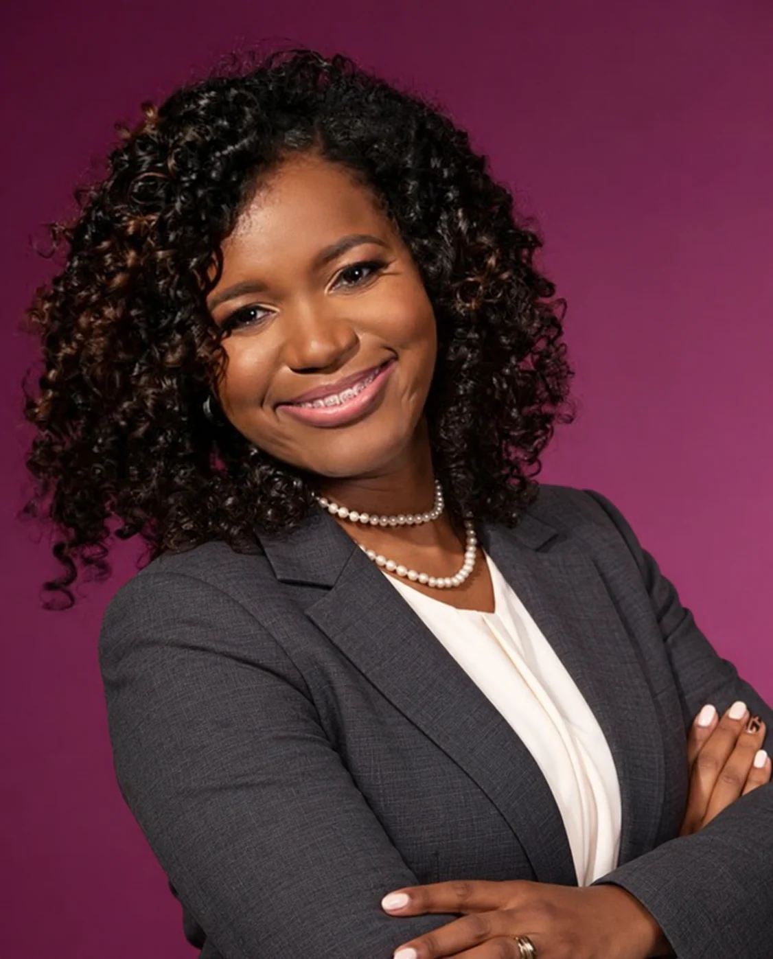 Dr. Shamika Strachan in a charcoal business suit and pearl necklace